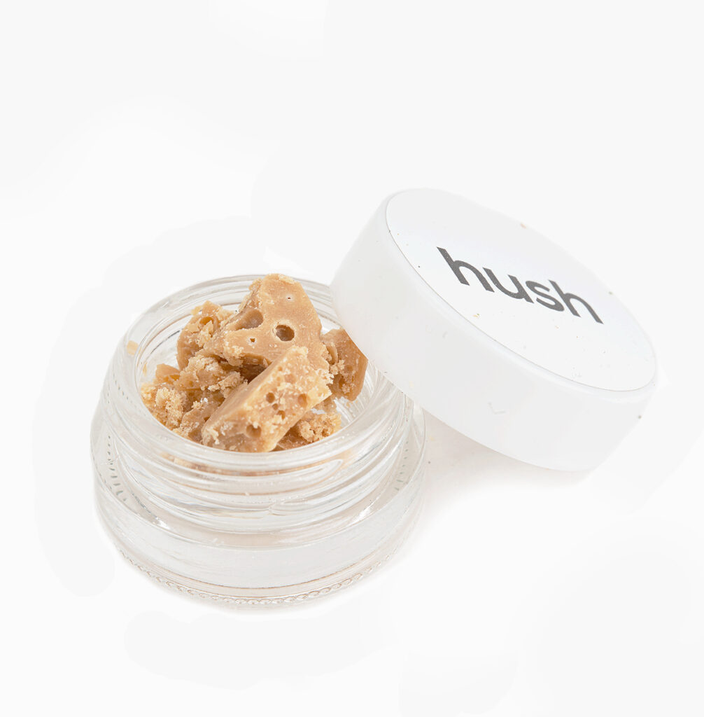 A small jar of Cactus Breath THC budder; it's light caramel in colour and crumbly in texture.