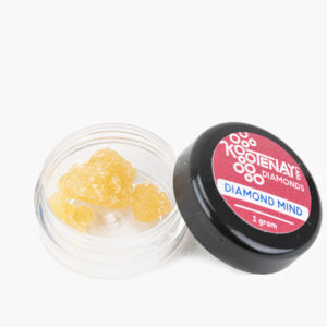 A small jar of Diamond Minds THC diamonds; the contents are golden and shaped like crystals.
