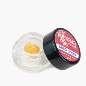 A small jar of Nitro Cookie THC Caviar produced by Kootenay Labs; the contents are deep gold and have the consistency of crystalized honey.
